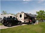 Motorhome in campsite with dinghy sharing space at DENTON FERRY RV PARK & CABIN RENTAL - thumbnail