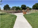 Paved footpath leads to play area with slides and swing sets at HEYBURN RIVERSIDE RV PARK - thumbnail