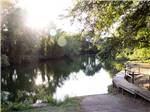 A wooden walkway follows the bank of a gentle pond at PARK RIDGE RV CAMPGROUND - thumbnail