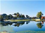 Serene pond with RVs on opposite bank at THE CREEKS GOLF & RV RESORT - thumbnail