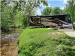 A motorhome in a backin site near the river at PINE MOUNTAIN RV PARK BY THE CREEK - thumbnail