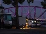 A line of RV sites with the bridge lit up in purple in the background at DOWNTOWN RIVERSIDE RV PARK - thumbnail