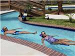 Two people floating in the lazy river at TWELVE OAKS RV PARK - thumbnail
