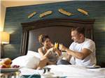 A couple sitting in bed drinking orange juice at LITTLE RIVER CASINO RESORT RV PARK - thumbnail