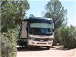 A Class A motorhome in a tree lined RV site at PAYSON CAMPGROUND AND RV RESORT - thumbnail