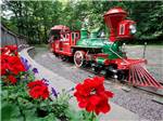 A green mini train takes a curve at WYLIE PARK CAMPGROUND & STORYBOOK LAND - thumbnail