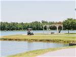 Two ladies in a golf cart by the lake at WILLOWTREE RV RESORT & CAMPGROUND - thumbnail