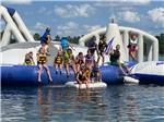 A group of kids sitting on the play structure floating on lake at WILLOWTREE RV RESORT & CAMPGROUND - thumbnail