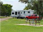 A picnic table in a grassy RV site at MID AMERICA CAMP INN - thumbnail