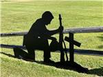 A silhouette of a soldier kneeling in front of a cross at PUMPKIN PATCH RV RESORT - thumbnail