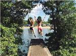 A couple of girls jumping off the dock at EMERALD LAKE TRAILER RESORT & WATERPARK - thumbnail