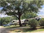 A row of travel trailers in paved sites at RV HIDEAWAY CAMPGROUND - thumbnail