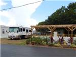 A motorhome next to a sitting area at TICE COURTS & RV PARK - thumbnail