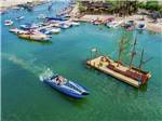An aerial view of a boat driving by the dock in the middle of the river at PIRATE COVE RESORT & MARINA - thumbnail