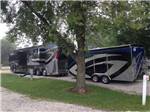 A motorhome pulling a trailer in a pull thru RV site at KAMP KOMFORT RV PARK & CAMPGROUND - thumbnail