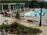 Campers swimming in pool, lounging pool side at TRAVERSE BAY RV RESORT - thumbnail