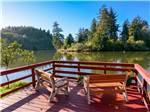 A deck with benches overlooking the water at HOQUIAM RIVER RV PARK - thumbnail