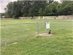 A dog statue in front of the fenced in pet area at CAPITAL CITY RV PARK - thumbnail