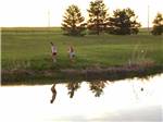 Two girls playing near the lake at FISHBERRY CAMPGROUND - thumbnail