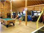 A woman playing pool at AMERICAN WILDERNESS CAMPGROUND - thumbnail