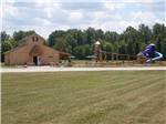 A building and playground equipment at AMERICAN WILDERNESS CAMPGROUND - thumbnail