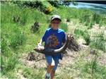 A young boy holding a fish at TOUTLE RIVER RV RESORT - thumbnail