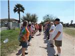 A woman walking between a line of people at LAZY PALMS RANCH RV PARK - thumbnail