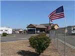 American flags waving on fence in front of office at FLAG CITY RV RESORT - thumbnail