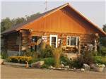 Log cabin office with Good Sam sign at TWIN PINES RV PARK & CAMPGROUND - thumbnail