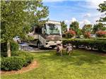 Motorhome in campsite, couple sitting in lawn chairs at TWO RIVERS LANDING RV RESORT - thumbnail