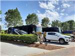 A motorhome and truck in a back in site at TWO RIVERS LANDING RV RESORT - thumbnail