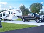A fifth wheel trailer and truck in a paver RV site at SUNSHINE VILLAGE - thumbnail