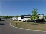 Large class A RV backed into open spot with lawn beside it at EZ DAZE RV PARK - thumbnail