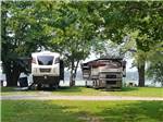 A couple of motorhomes by the water at BIRDSVILLE RIVERSIDE RV PARK - thumbnail