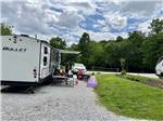A travel trailer parked in a gravel site at A motorhome in a gravel RV site with a patio at FRANKLIN RV PARK & CAMPGROUND - thumbnail