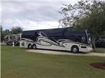 A large Class A motorhome in a paved RV site at GERONIMO RV PARK - thumbnail