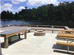 A fire pit and sitting area by the water at COASTAL GEORGIA RV RESORT - thumbnail
