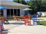 Red and blue rocking chairs and building under a sunny sky at MADISON VINES RV RESORT & COTTAGES - thumbnail