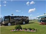 RVs in grassy area and flower bed at ST. ALBERT RV PARK - thumbnail