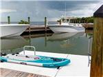 Boats tied to docks and paddle board in the foreground at GRASSY KEY RV PARK AND RESORT - thumbnail