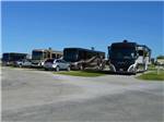 RVs in paved back-in sites with bright blue skies at COFFEE CREEK RV RESORT & CABINS - thumbnail