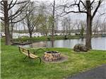 A fire pit with benches by the water at LAKEVIEW RV PARK - thumbnail