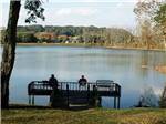 A couple of people sitting on a dock at LAKEVIEW RV PARK - thumbnail