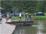 Man on fishing dock lifts up a fish with net at FISH'N FRY CAMPGROUND & RV PARK - thumbnail