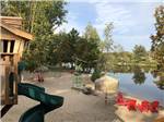 A sitting area and playground by the water at SID TURCOTTE PARK CAMPING AND COTTAGE RESORT - thumbnail