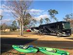 Class A motorhome parked in site with kayaks next to it at FLORIDA CAVERNS RV RESORT AT MERRITT'S MILL POND - thumbnail
