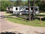 Large motorhomes parked on gravel sites among the trees at SHERWOOD FOREST CAMPING & RV PARK - thumbnail