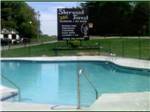 A view of the swimming pool with the park sign at SHERWOOD FOREST CAMPING & RV PARK - thumbnail