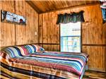 A bed with a striped bedspread at HATTERAS SANDS CAMPGROUND - thumbnail