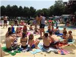 A group of kids sitting around a pool at SEA-VU CAMPGROUND - thumbnail